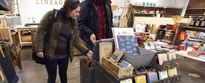 A man and a woman browsing items at Lineage shop in the Agora Market.