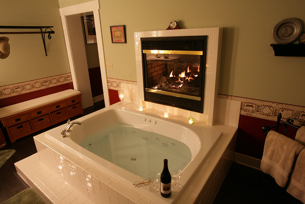 Large bath tub with fireplace next to it 