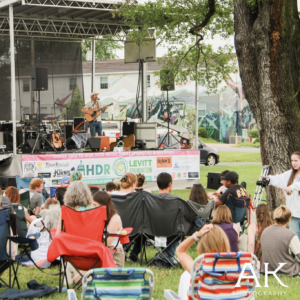People sitting in lawn chairs watching a concert outside