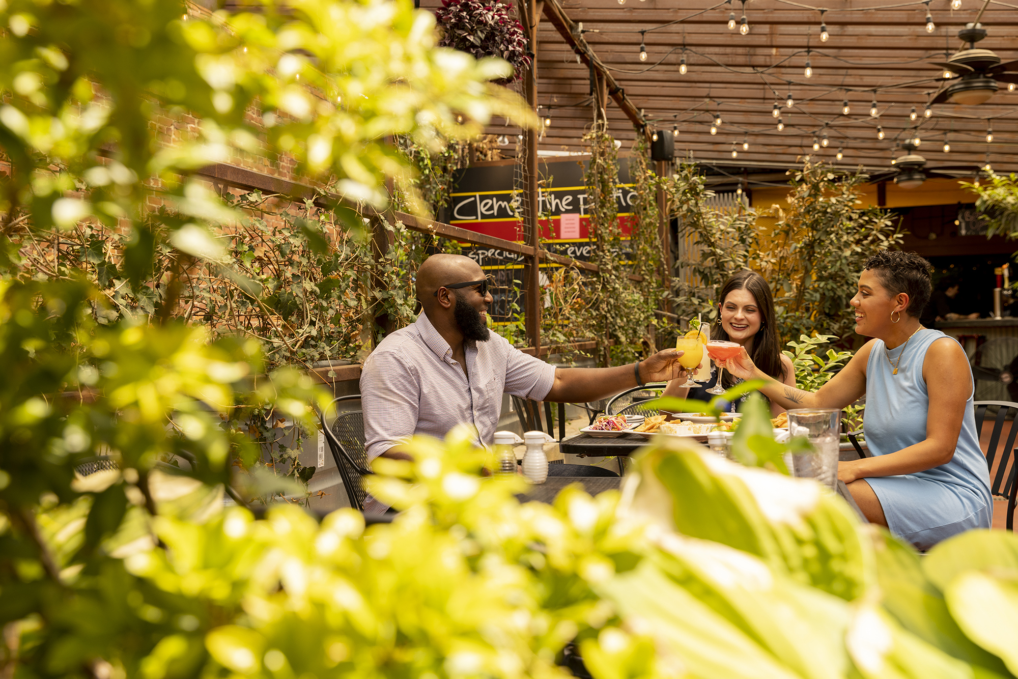 Group raising a toast at a local restaurant on an outside patio