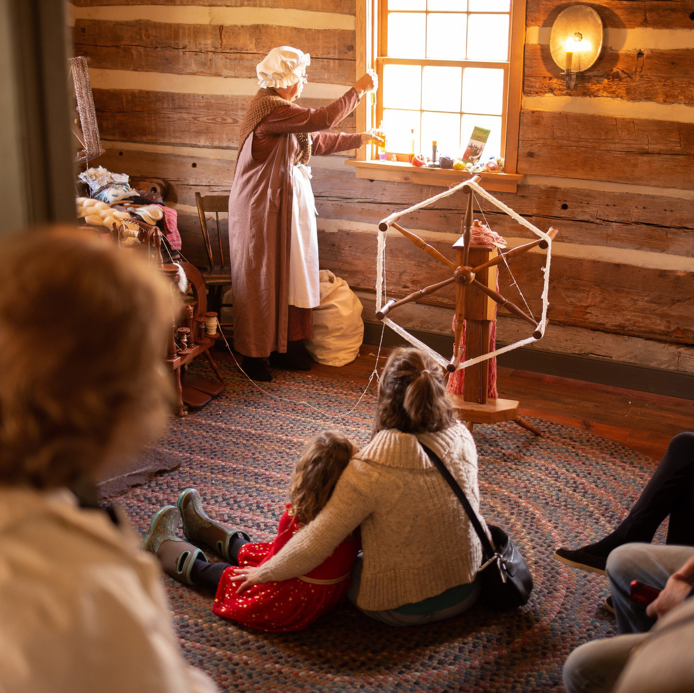 People watching a women make yarn