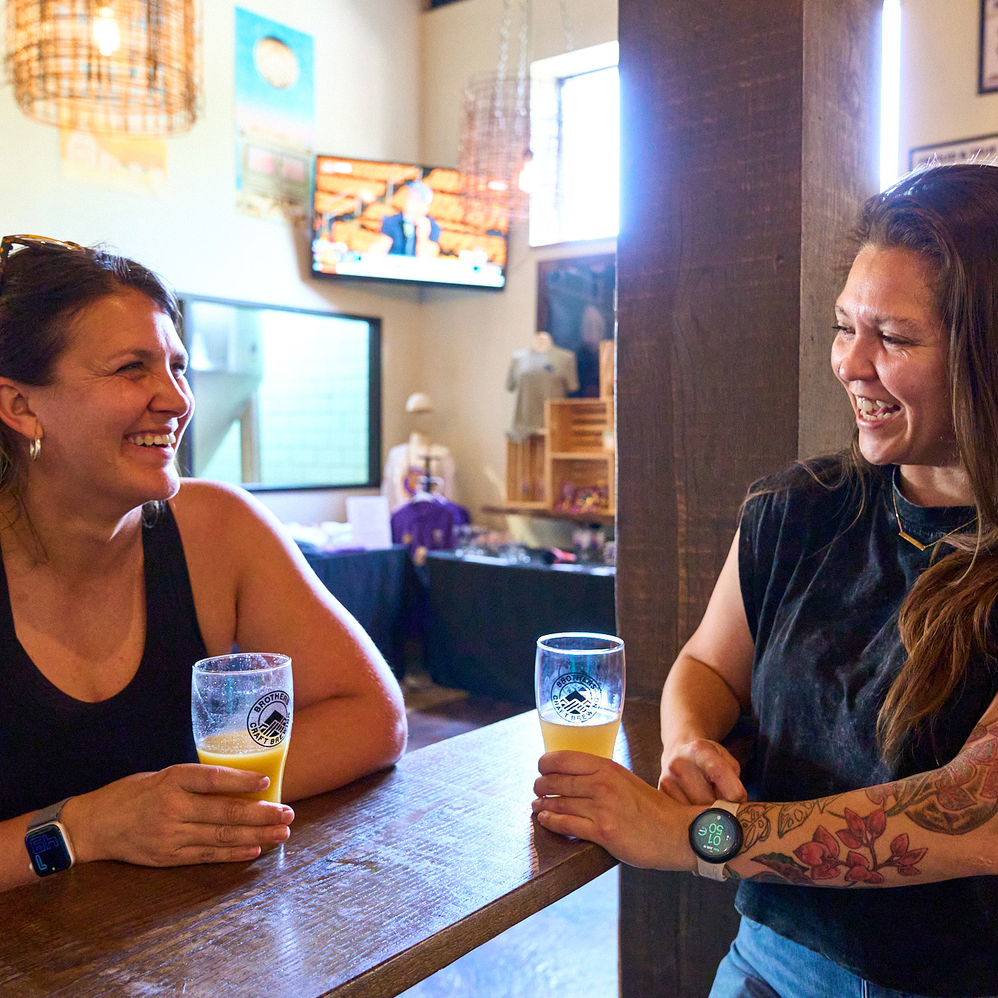 2 ladies laughing with beers at Brothers craft brewing