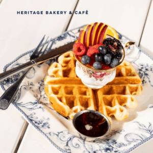 A plate full of a waffle and fruit from Heritage Bakery and Cafe.