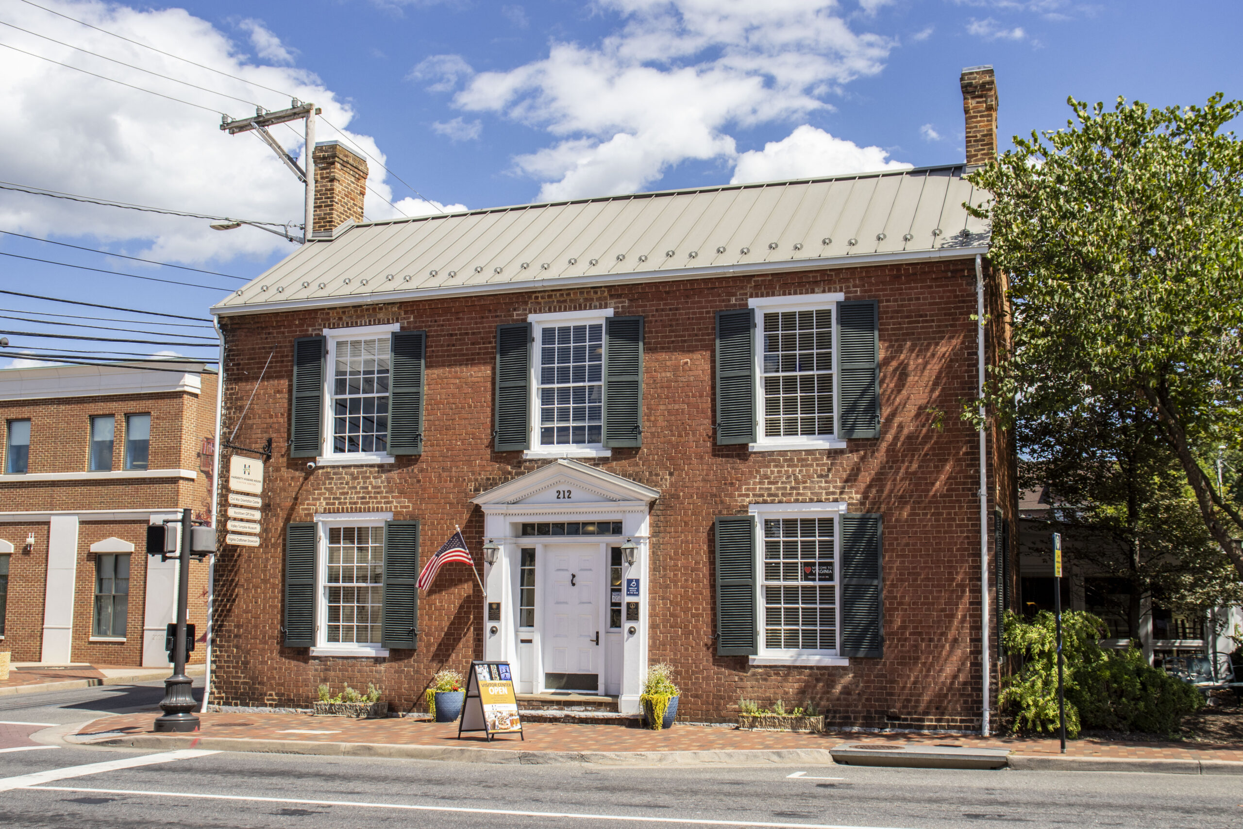 The brick Hardesty-Higgins House Visitor Center on a partly cloudy day.