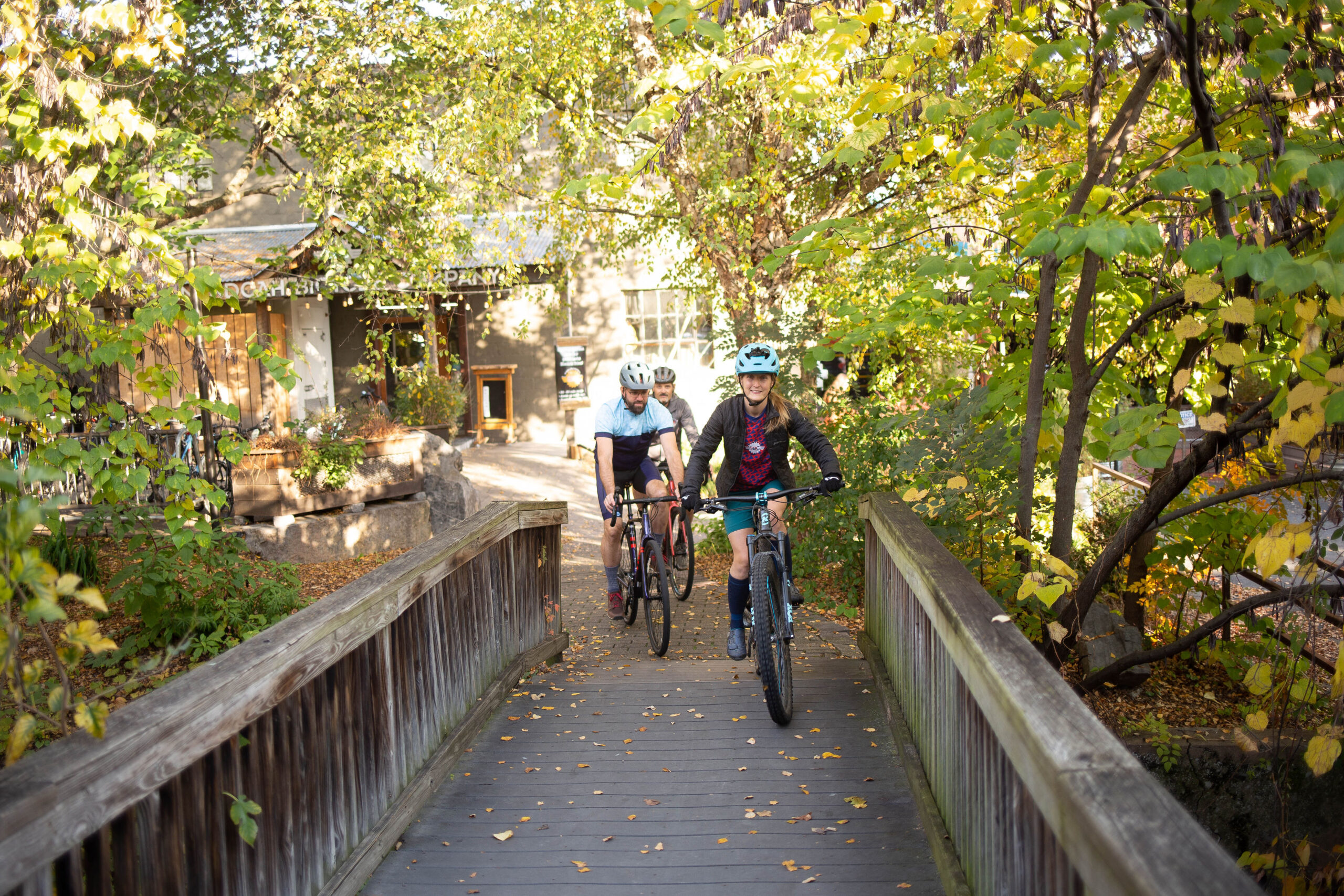 Bikers riding across a bridge leaving Shenandoah Bicycle Company.