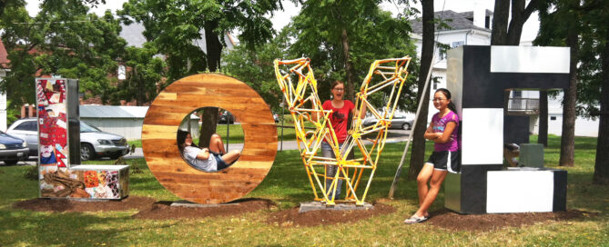 Girls on LOVE statue posing for a picture