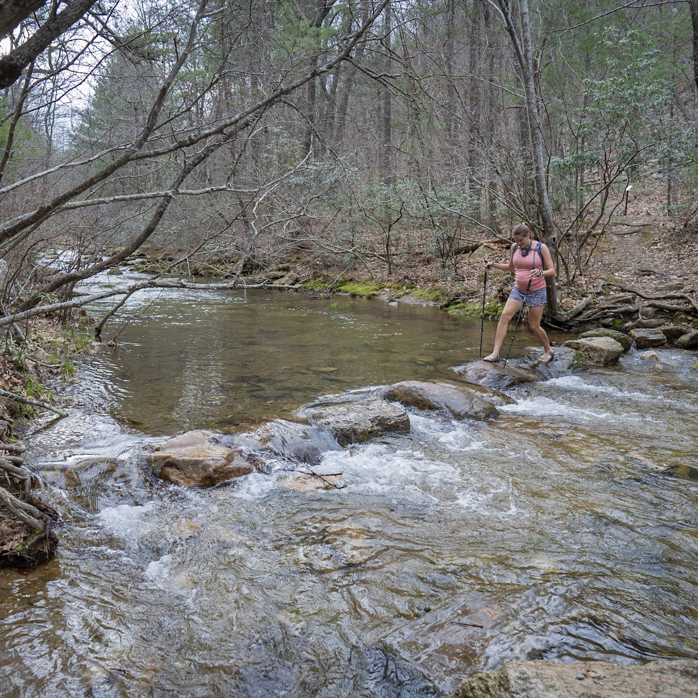 Woman walking on rocks through water