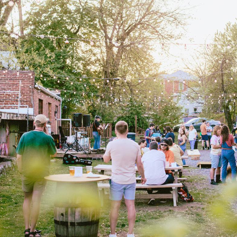 People outside and person playing the guitar and singing outside restless moons