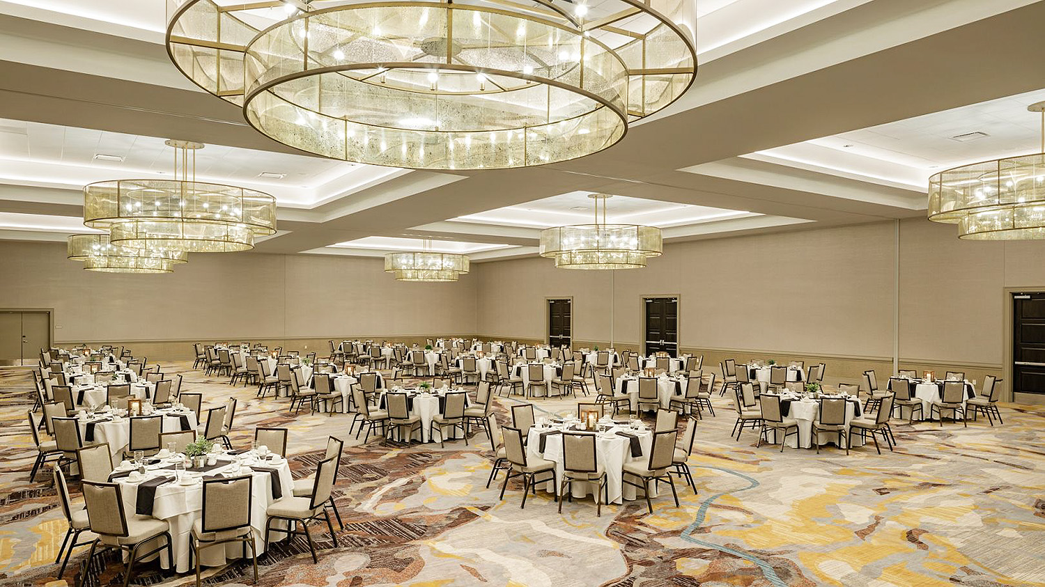 Large conference room with large chandeliers and set up with round tables