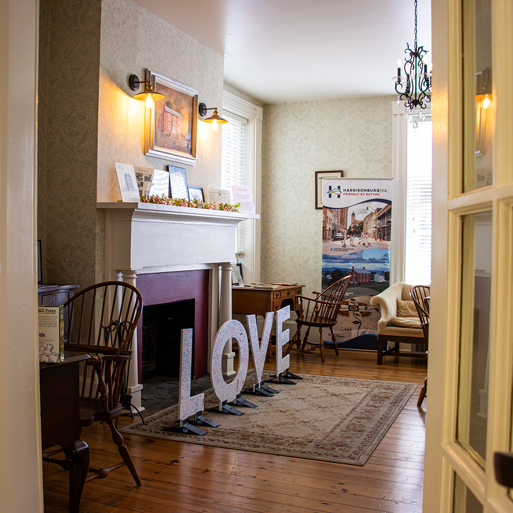 View of the Virginia Craftman showroom with fireplace, Love sign, and furniture.