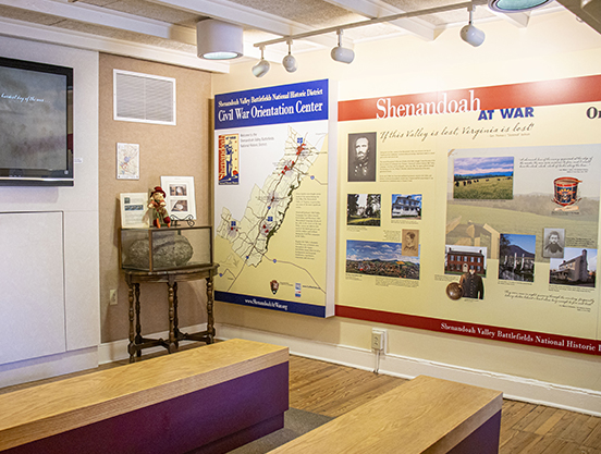 Inside the Civil War Orientation Center with displays, benches, and television