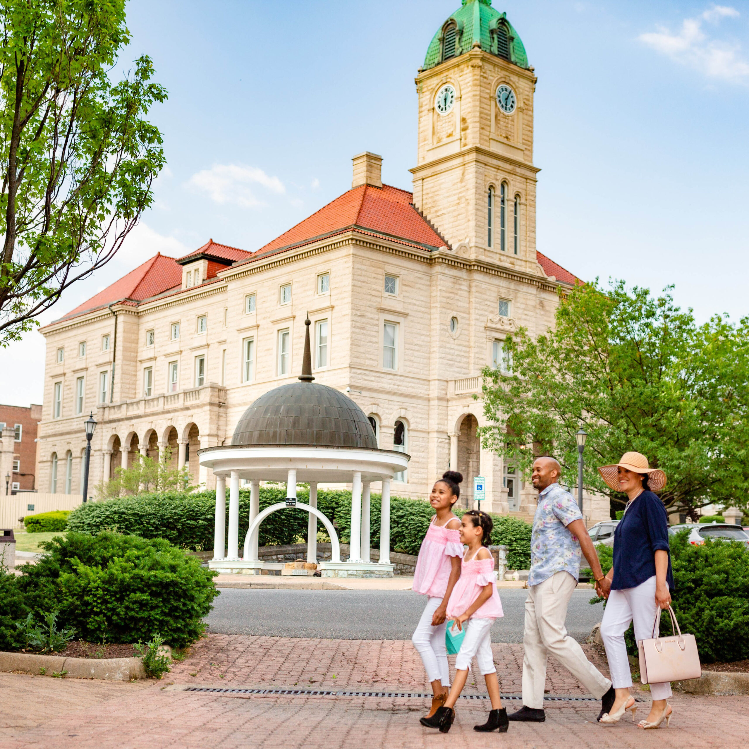 Family walking in front of court house on a sunny day