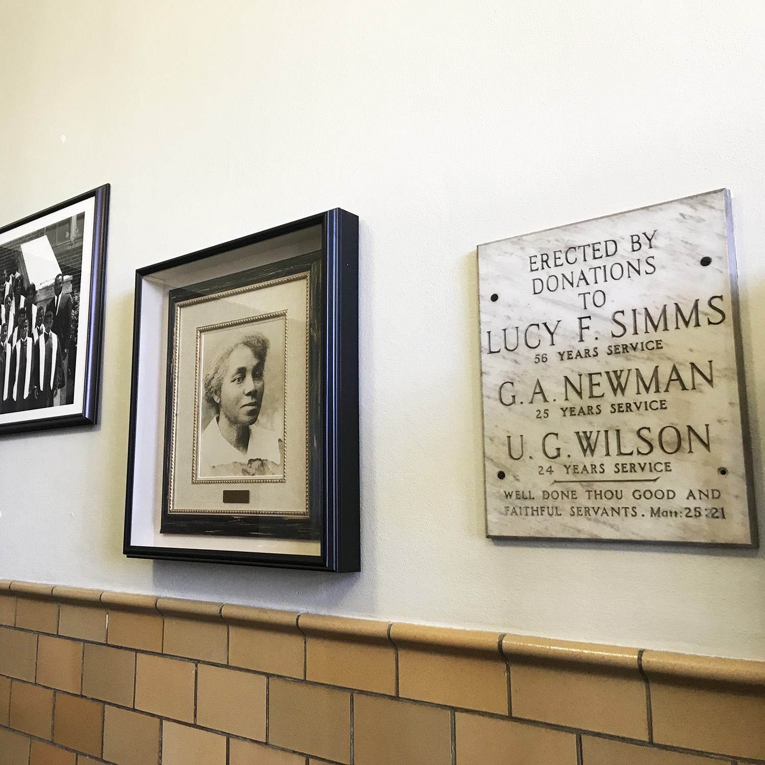 portrait of Lucy Simms and a plaque about donators hung on the wall