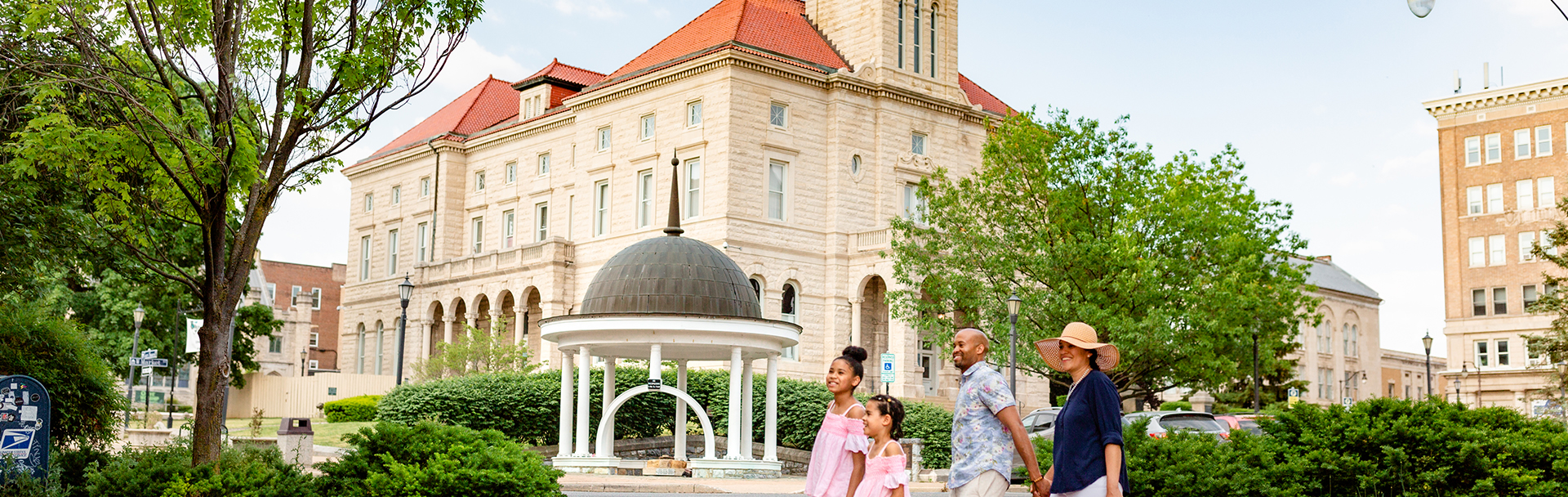 Family walking by the spring house and court house in downtown harrisonburg