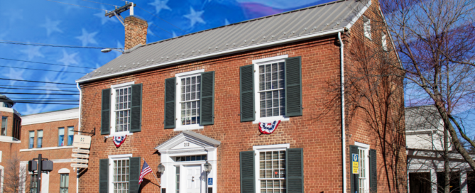 Hardesty Higgins House with red, white, and blue banners under the window. Faded U-S flag generated to take up the blue sky.