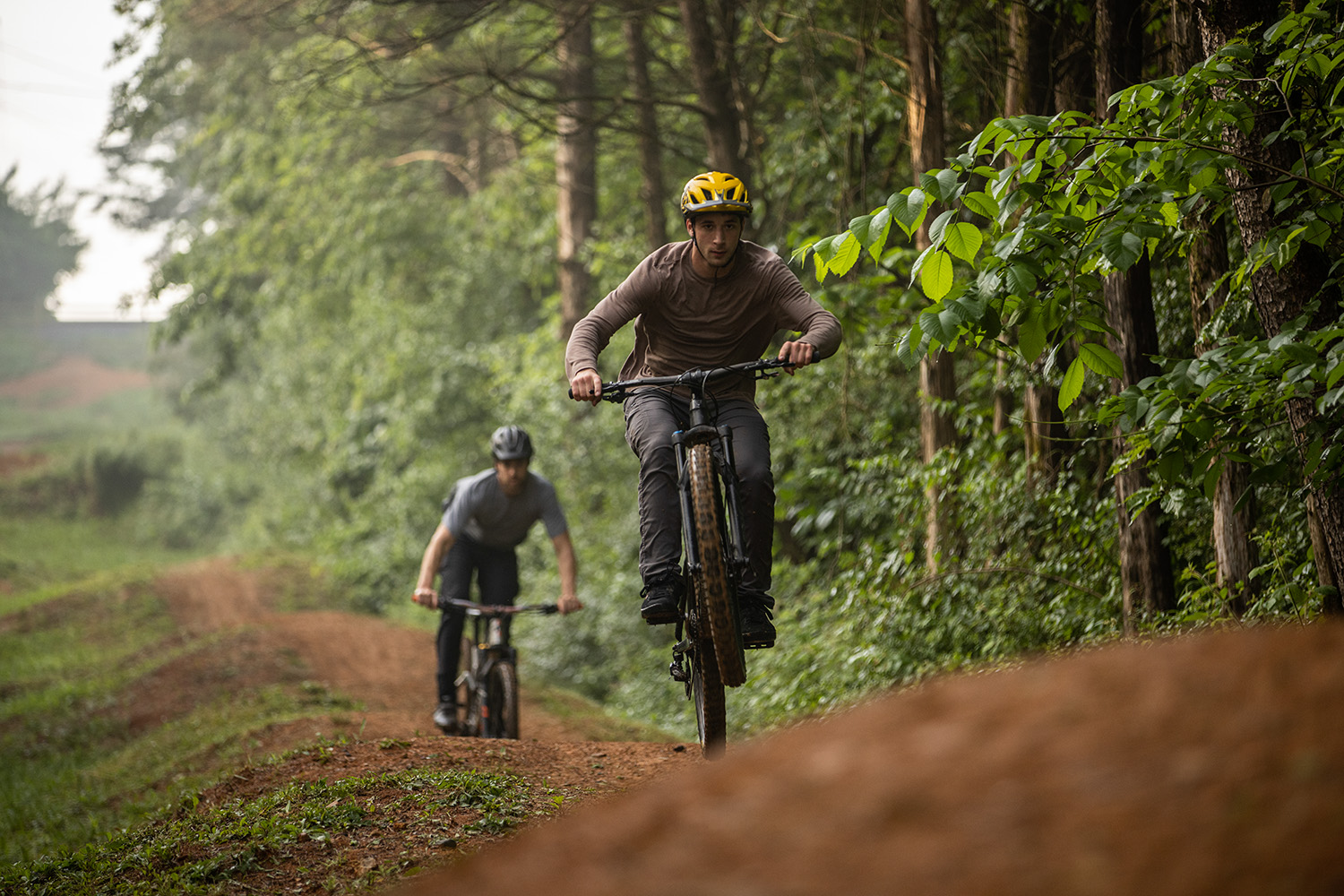 Bikers riding on a dirt trail.
