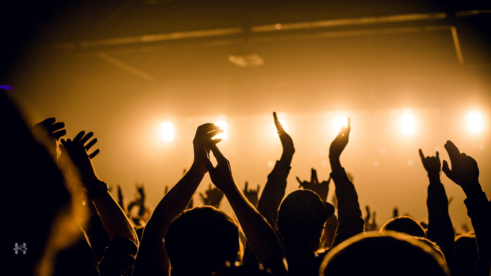 Concert lights with hands raised in front of the stage.