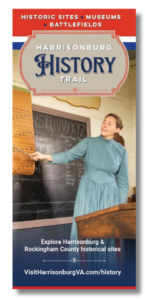 Cover of History Trail brochure with a woman in a blue dress pointing at a chalk board in a historic school house