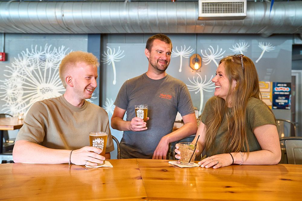 Pale Fire Brewing_Web Three people smiling and enjoying beer at Pale Fire Brewing