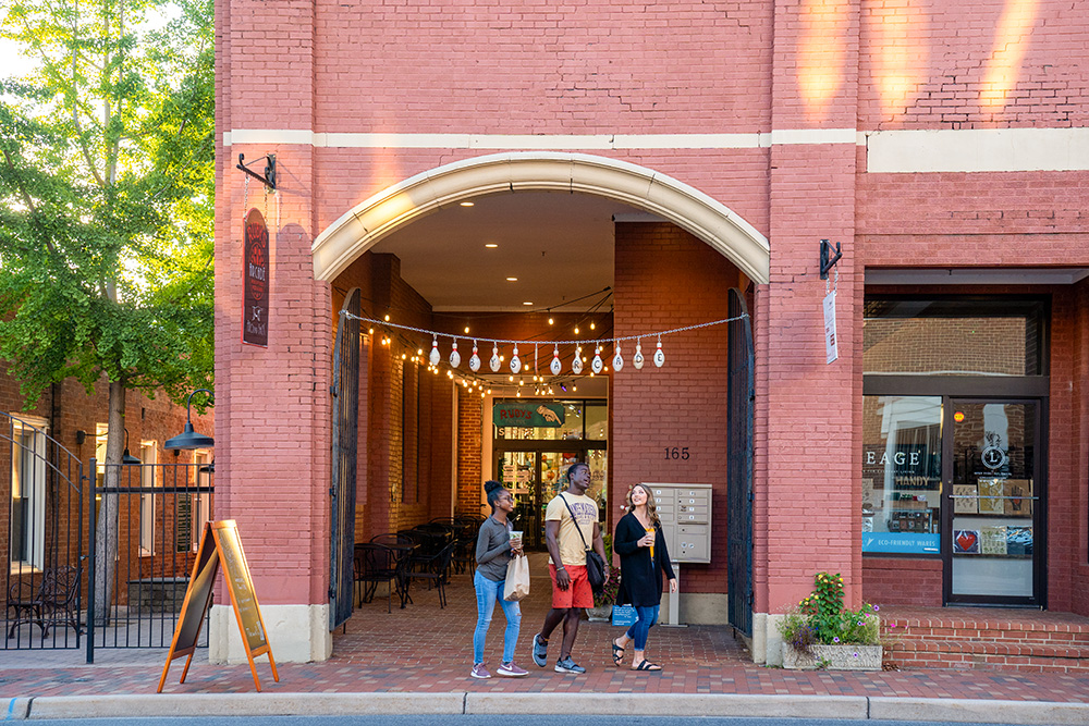 People walking out of Agora Market in front of the brick building
